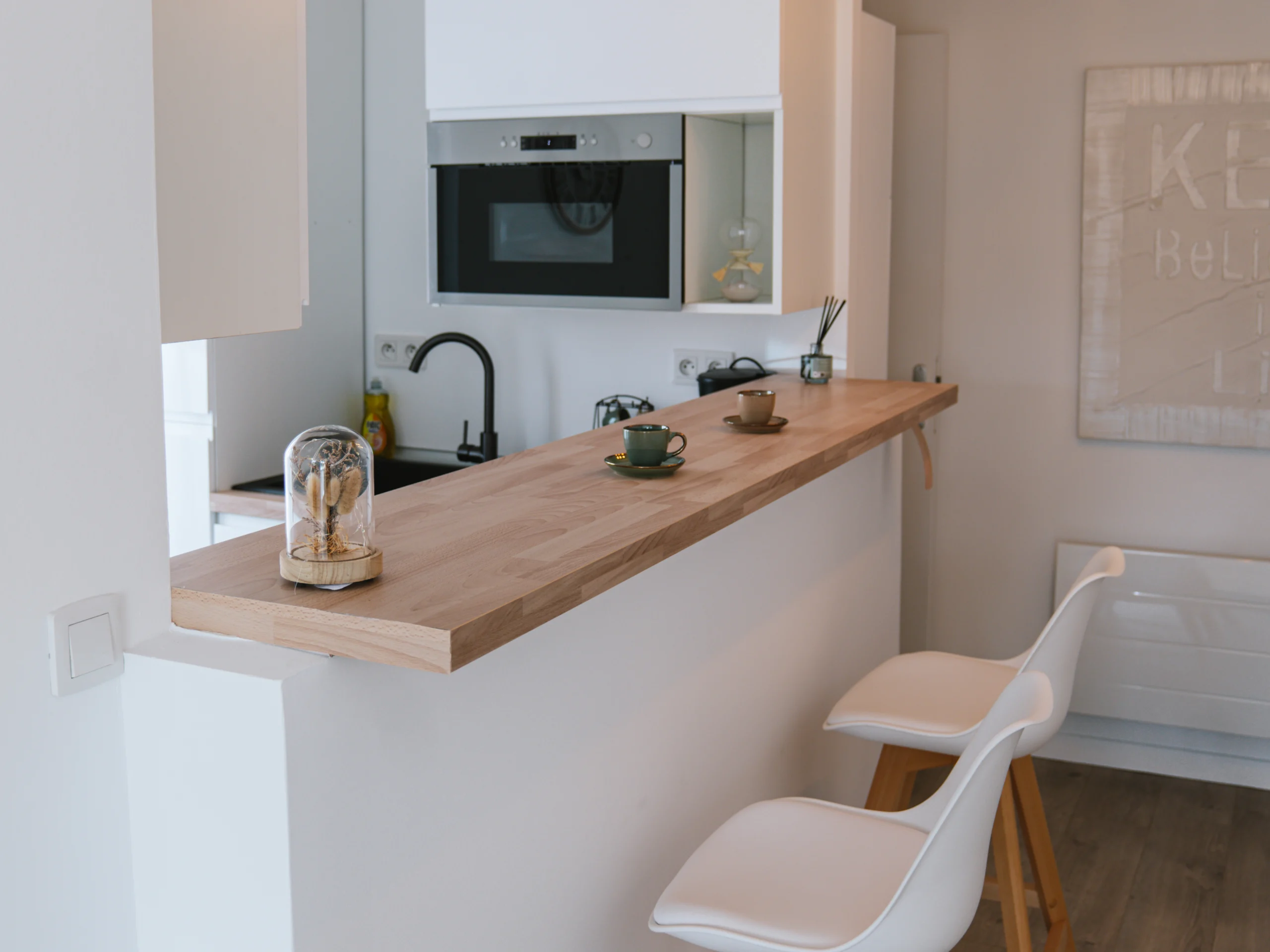 Photo d&rsquo;une cuisine avec bar en bois et chaises hautes